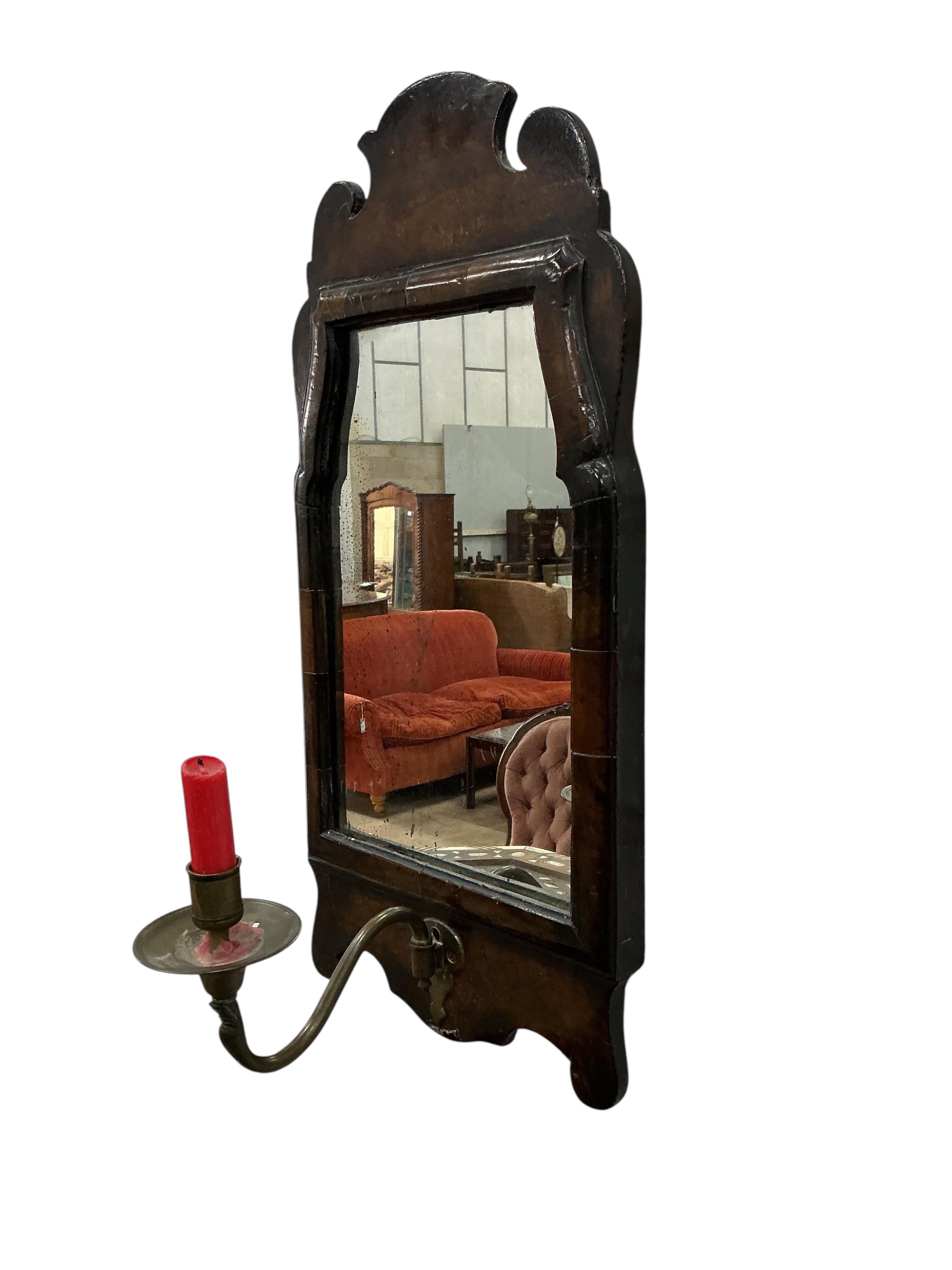 A small 18th century style walnut fret cut wall mirror, with a brass candle sconce, width 24cm, height 50cm